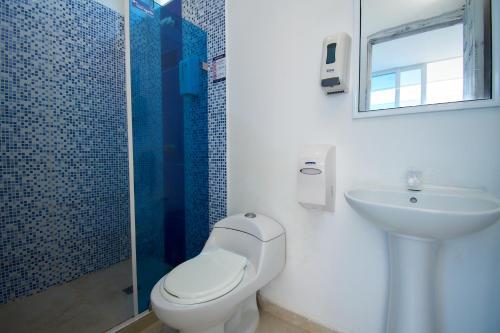 a bathroom with a toilet and a sink and a shower at Hotel Palma Linda in Coveñas