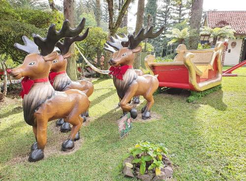 a statue of three deer with antlers in the grass at Pousada Natal Encantado in Gramado