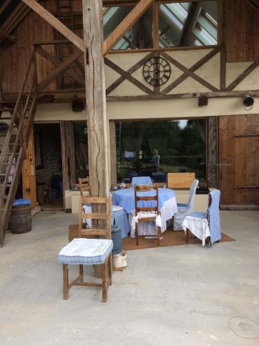 a room with a table and chairs in a barn at CHAMBRE JEAN'S CHEZ L'HABITANT à LAMBALLE in Lamballe