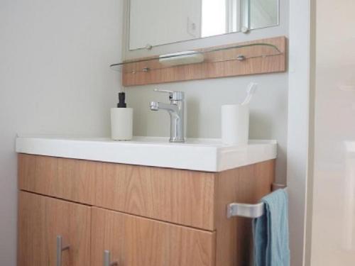 een badkamer met een wastafel en een spiegel bij Chalet op Camping Lauwersoog met 3 slaapkamers en vaatwasser - JoyCasa in Lauwersoog