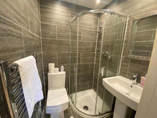 W łazience znajduje się prysznic, toaleta i umywalka. w obiekcie Roundhay Apartments w mieście Leeds