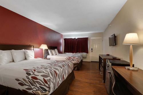 a hotel room with two beds and a desk at Red Roof Inn Needles in Needles