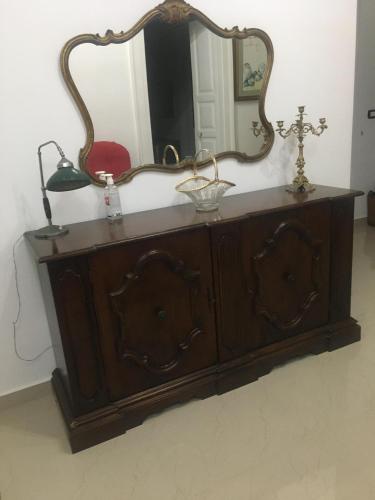 a wooden dresser with a mirror on top of it at Stelmalu' in Novoli