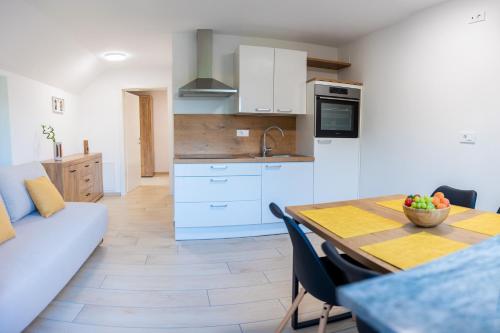 a kitchen and dining room with a table and a couch at Na-Ture Apartments in Zgornje Gorje