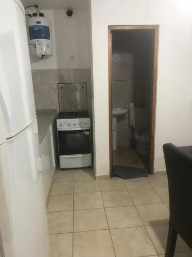 a small kitchen with a stove and a toilet at Remedios de escalada Suite! Wifi Aire cable in Villa María
