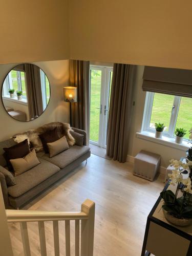 uma sala de estar com um sofá e um espelho em Gleneagles Holiday Home em Auchterarder