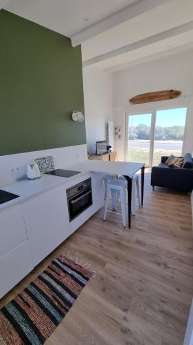 une cuisine avec un comptoir blanc et une table dans l'établissement Stella Cab'in, à Cucq