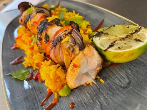 a plate of food with meat and rice and a lime at The Bell Hotel Aylesbury in Aylesbury