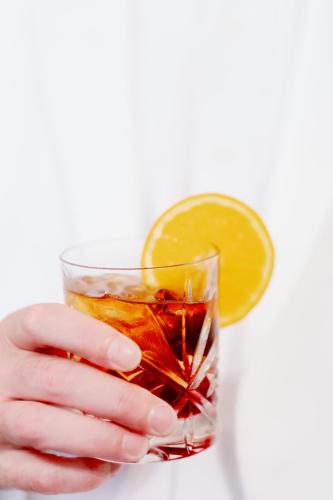 a hand holding a drink with a lemon slice at The Faust Hotel in New Braunfels
