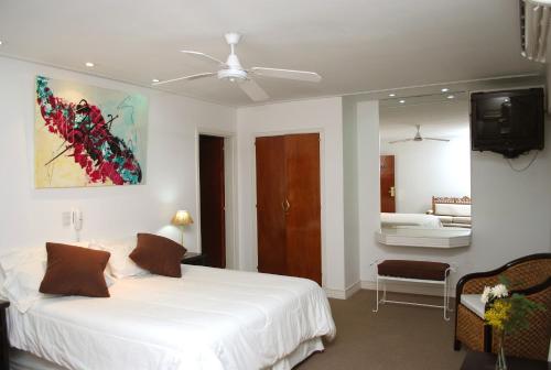ein Schlafzimmer mit einem großen weißen Bett und einem TV in der Unterkunft Hotel Corbel Superior in Mar del Plata