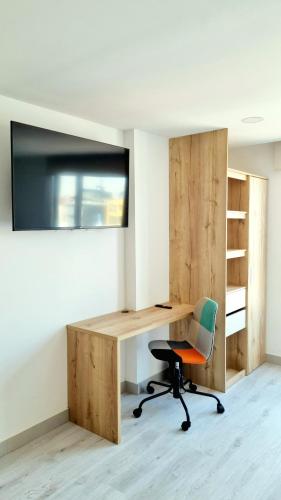 an office with a wooden desk and a chair at Toscana LOFT - Apartasuites in Bogotá