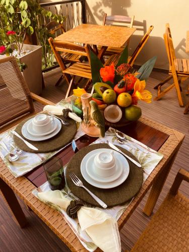 a table with two plates and a bowl of fruit at Beach Eco Stays Hotel Boutique Lagoinha in Tigre