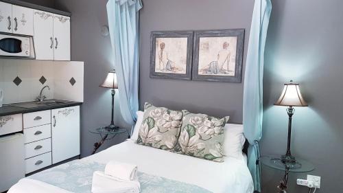 a small bedroom with a bed with blue curtains at Lamon Guesthouse in Kroonstad