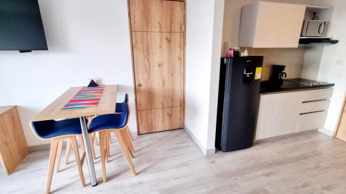 a small kitchen with a small table and a refrigerator at Toscana LOFT - Apartasuites in Bogotá