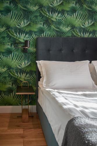 a bedroom with a bed with a green leafy wall at The Embassy Suites in Sofia