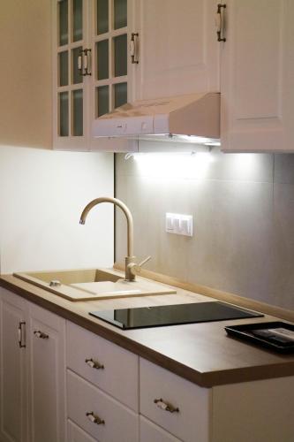 a kitchen with white cabinets and a sink at Sessa's Palace in Korčula