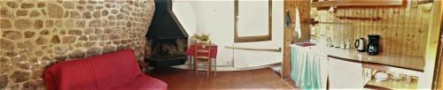 - un salon avec un canapé rouge et un mur en pierre dans l'établissement La Ferme de Leix, à Clergoux