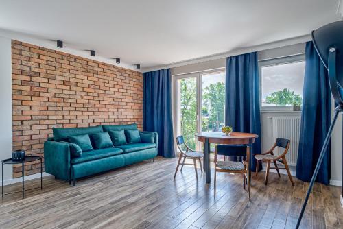 un soggiorno con un divano blu e un tavolo di Apartament Wschodni a Supraśl
