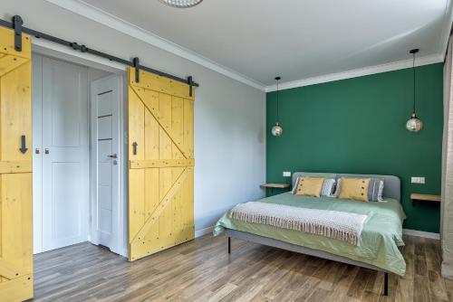 una camera da letto con un letto e una parete verde di Apartament Wschodni a Supraśl
