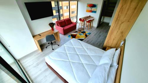 a view of a bedroom with a bed and a living room at Toscana LOFT - Apartasuites in Bogotá
