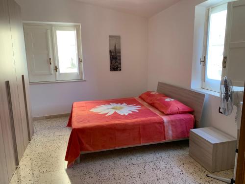 a bedroom with a red bed with a flower on it at Casavacanze Alba in Alcamo