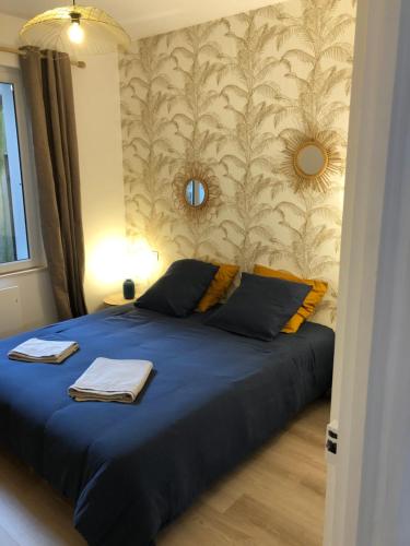 - une chambre avec un lit bleu et un mur dans l'établissement L'Air de la Mer, 2 chambres, 50m plage, parking, à Houlgate