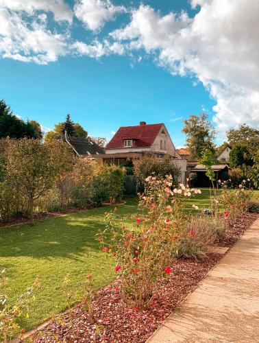 a house with a garden with flowers in the yard at Karowlina Cozy House Berlin 1-4 Person in Berlin