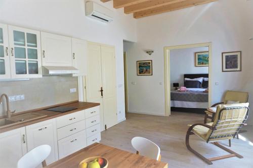 a kitchen with a table and a chair and a bed at Sessa's Palace in Korčula
