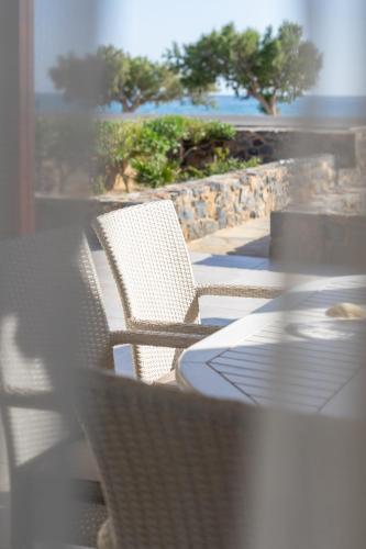 a table and chairs on a patio with a view of the ocean at Blue Coast House in Goúdhouros