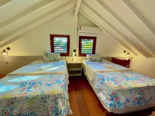 duas camas num quarto com duas janelas em Ap. Estrela do Mar - Pé na areia com vista para o mar e piscina em Barra Grande