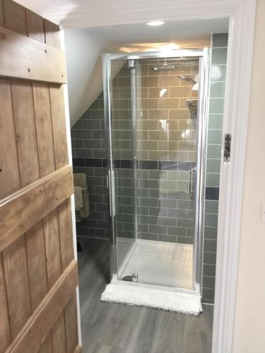 una doccia con porta in vetro in bagno di Oaks Barn a Chinnor