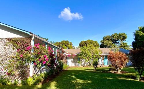 a house with pink flowers and a fence at Kahina Lodge in Hanga Roa