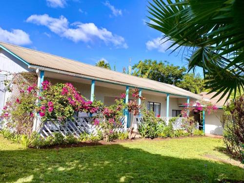 une maison avec des fleurs devant elle dans l'établissement Kahina Lodge, à Hanga Roa