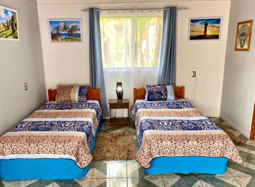 a room with two beds and a window at Kahina Lodge in Hanga Roa