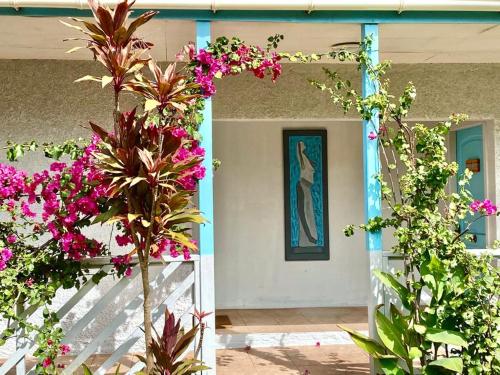 a house with pink flowers on the front porch at Kahina Lodge in Hanga Roa