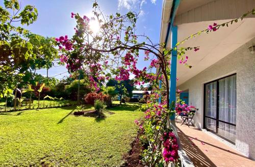 a garden with pink flowers on the side of a building at Kahina Lodge in Hanga Roa