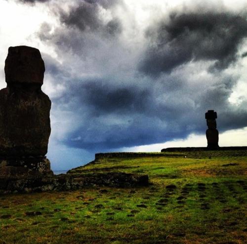 a field with two large rocks on top of a hill at Kahina Lodge in Hanga Roa