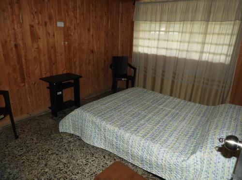1 dormitorio con cama, mesa y ventana en Hostal San Ramon en Santa Rosa de Cabal