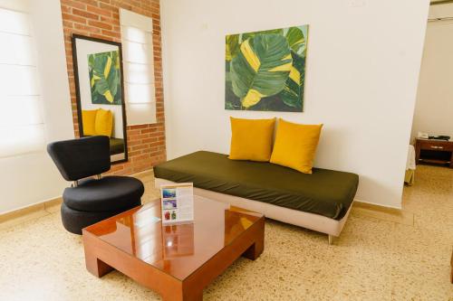 a room with a bed and a table and a chair at HOTEL OSCAR Tradición in Apartadó