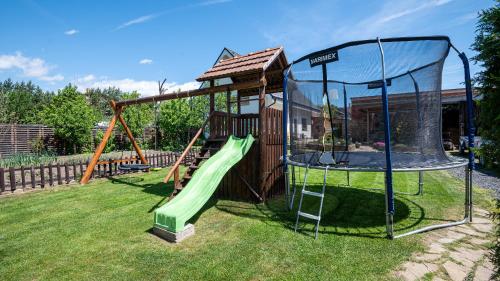 a playground with a slide in a yard at Apartman Valnela in Veľká Lomnica