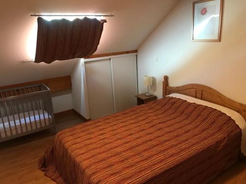 Saint-PancraceにあるT2 bis duplex 6 couchages situé aux BOTTIERESのベッドルーム1室(オレンジ色の毛布付きのベッド1台付)