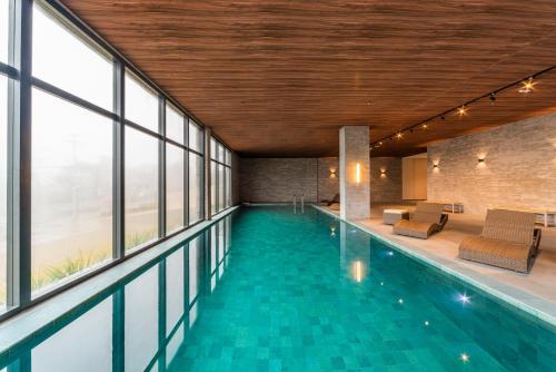 a swimming pool in a building with windows at Laghetto Canela in Canela