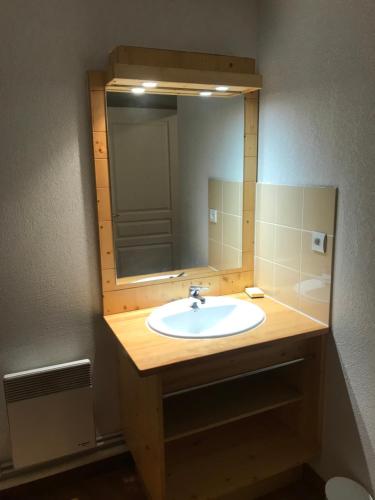 une salle de bain avec un lavabo et un miroir dans l'établissement T2 bis duplex 6 couchages situé aux BOTTIERES, à Saint-Pancrace