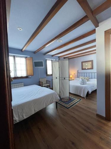 a large room with two beds and a room with twoermott at Hotel Rural As Laguas in Tapia de Casariego