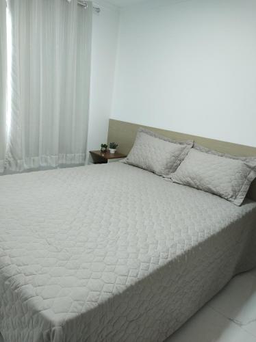 1 cama blanca grande en un dormitorio blanco en Apartamento Encantador Centro Santa Teresa en Santa Teresa