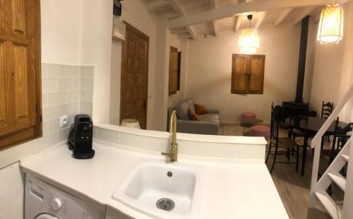 een keuken met een wastafel en een woonkamer bij La casita de El Montán in Avilés