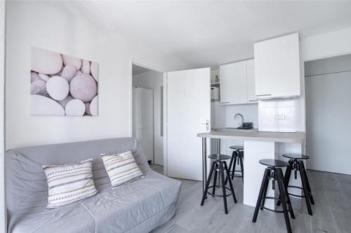 uma sala de estar branca com um sofá e uma cozinha em Cosy Apt Of 25 M Near The City View On Sea em La Seyne-sur-Mer