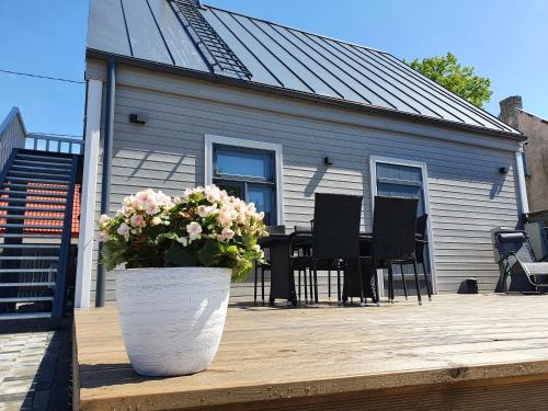 a house with a pot of flowers on a wooden deck at KK Apartment in Ventspils