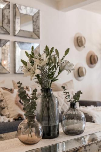 two vases with flowers in them on a table at Casa Recreo King Suite Apartments in Centro, San Miguel de Allende in San Miguel de Allende