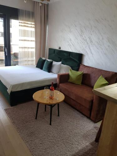 a bedroom with a bed and a couch and a table at Soho Magic Lux in Bar